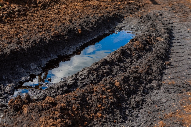 Un charco de petróleo crudo derramado en la rutina del camión. Desastres ambientales, contaminación, daños al medio ambiente.