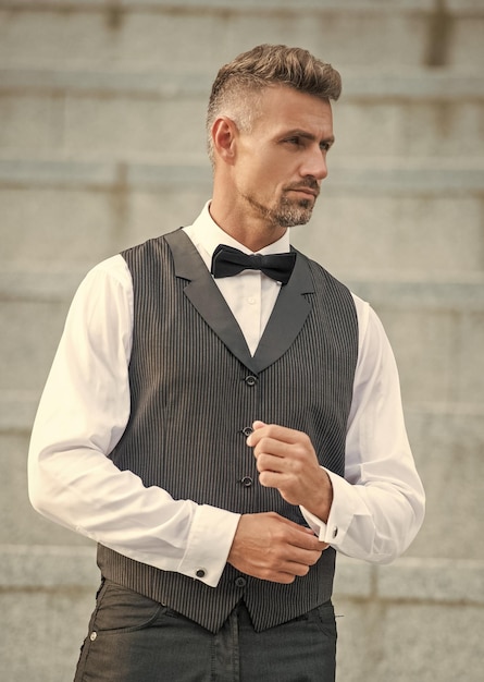 charismatischer, eleganter Mann mit Fliege, grauer Mann in Formalkleidung, Smoking, Bräutigam