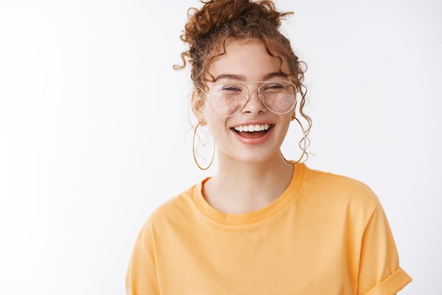 Charismatisches junges rothaariges Mädchen mit Brille, das laut lacht