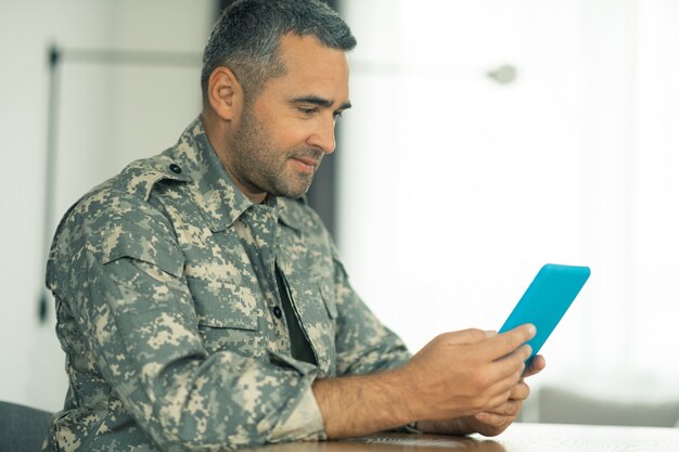 Charle con la familia. Serviceman sosteniendo la tableta mientras tiene video chat con la familia mientras los extraña