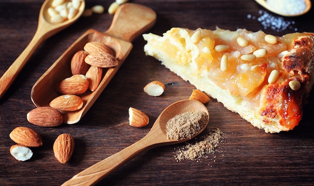 Charlotte con manzanas y nueces. Preparación de manzana para hornear con nueces y miel. Postre productos horneados de manzanas y nueces con miel sobre una mesa de madera.