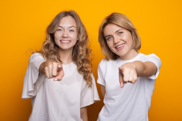 Charmante blonde Frauen zeigen nach vorne