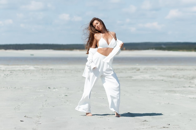 Charmante Frau, die am Strand steht