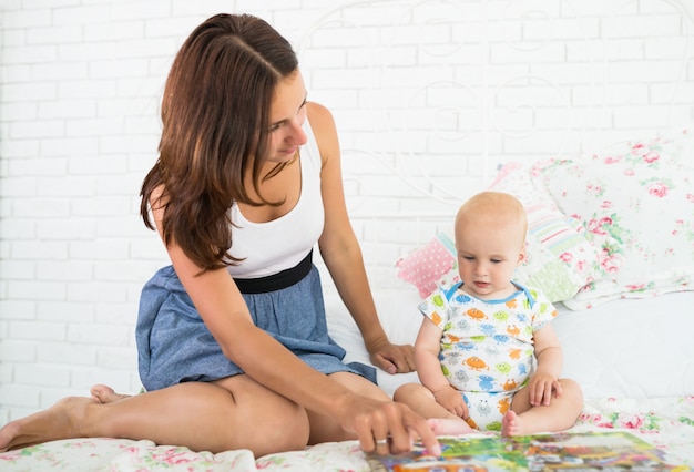 Charmante junge Mutter ruft zu ihrem kleinen Baby