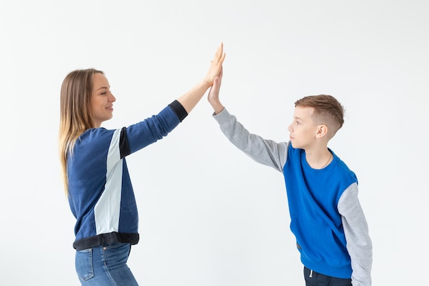 Charmante Mutter und Sohn klatschen sich gegenseitig und genießen den perfekten Umzug in eine neue Wohnung. Das