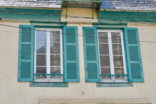 Charmante Vintage-Fenster mit bunten Fensterläden auf dem Retro-Haus draußen in der Stadt Arreau in Frankreich