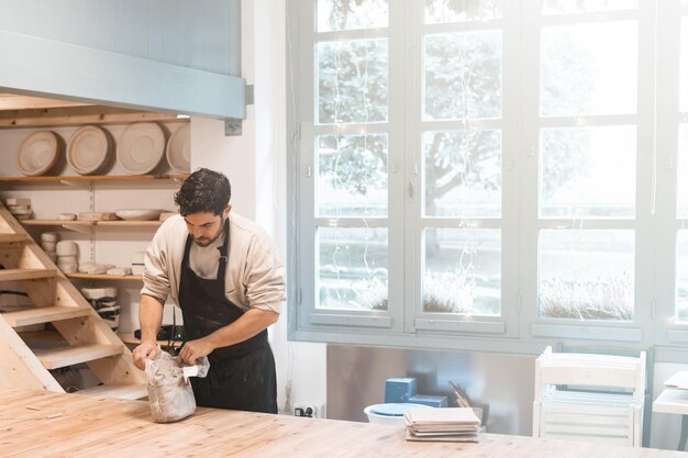 Charmanter Handwerker, der die Keramikkunst und den Produktionsprozess genießt