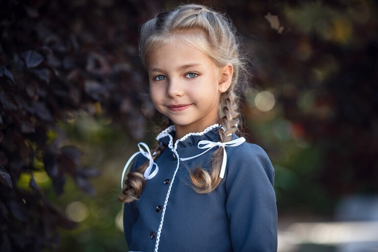 Charmantes kleines Mädchen in einem Retro-Kleid, das in der Stadt an einem sonnigen Sommertag geht. Kleines Mädchen tragen Schuluniform.