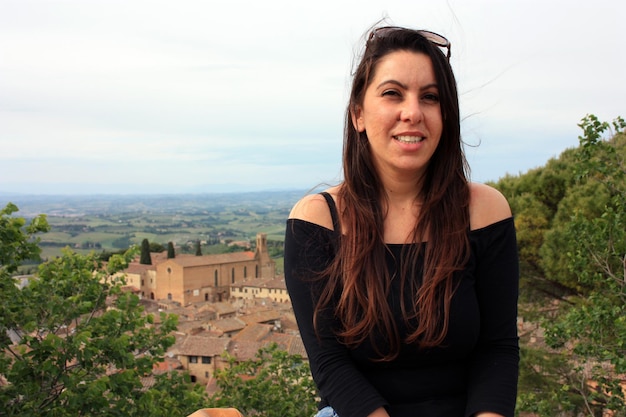Charmosa morena garota caucasiana e fundo de medieval montanhosa Toscana San Gimignano na Itália