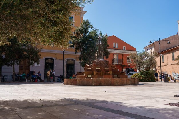Charmosa plaza sarda con fuente y edificios de colores
