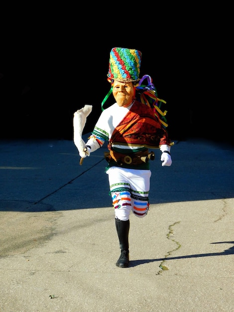 Un charrelo con un traje colorido corre por una calle.