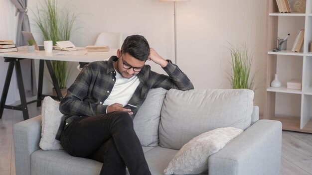 Foto chateo por teléfono gadget de ocio en el hogar hombre sofá celular