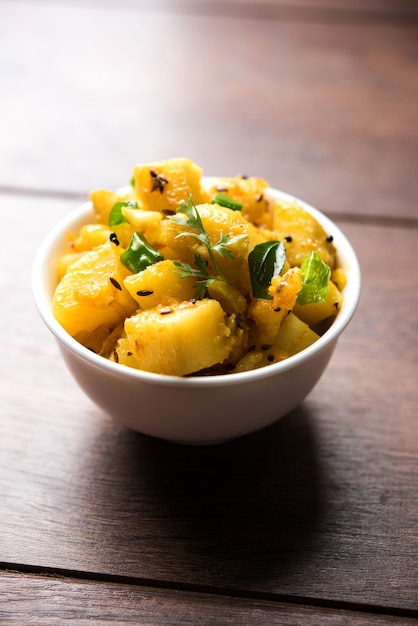 Chatpate Masala Aloo Sabzi fry o patatas Bombay servidas en un recipiente, el enfoque selectivo