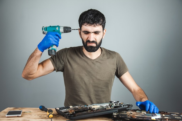 Foto chave de fenda de mão de homem na cabeça em fundo cinza