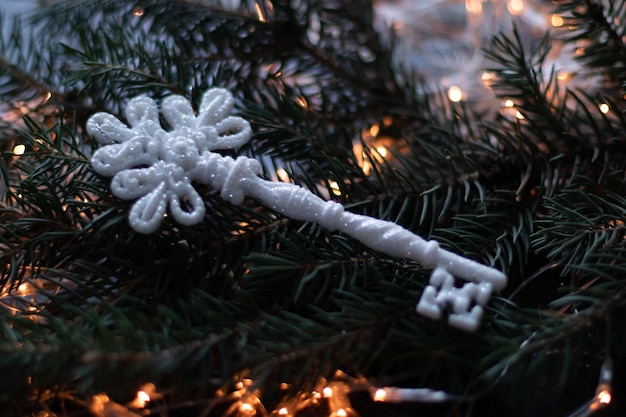 Chave de natal no galho da árvore de natal com guirlanda efeito bokeh Foto Premium