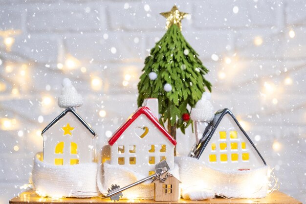 Chave para a casa com um chaveiro em uma casa aconchegante com uma decoração de Natal Um presente para o Ano Novo Projeto de construção do edifício movendo-se para uma nova casa hipotecária aluguel e compra de imóveis
