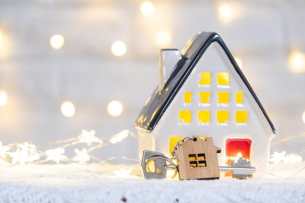 Chave para a casa com um chaveiro em uma casa aconchegante com uma decoração de Natal Um presente para o Ano Novo Projeto de construção do edifício movendo-se para uma nova casa hipotecária aluguel e compra de imóveis