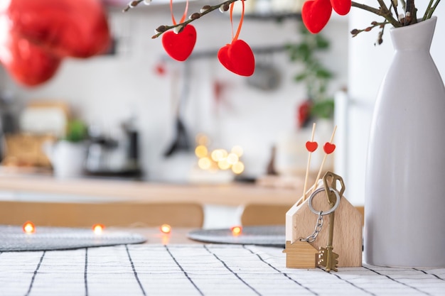 Chave para uma casa aconchegante com decoração de dia dos namorados na mesa da cozinha Presente para o dia dos namorados ninho de amor familiar Projeto de construção movendo-se para uma nova casa hipotecária aluguel e compra de imóveis