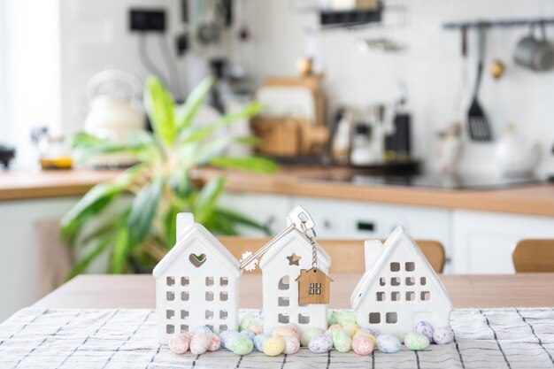 Chave para uma casa aconchegante com decoração de Páscoa com coelho e ovos na mesa da cozinha Projeto de design de construção movendo-se para uma nova casa seguro de hipoteca aluguel e compra de imóveis