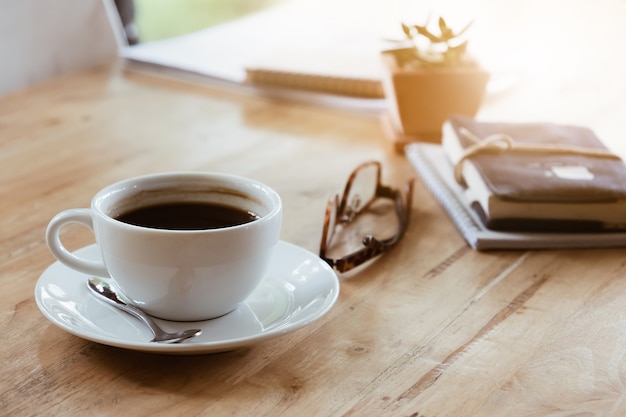 Chávena de café na mesa de madeira em casa na luz da manhã. Hora do café.