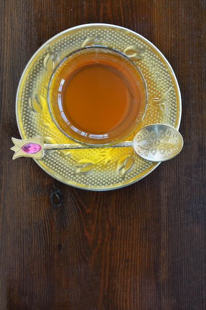 Chávena de chá turca com colheres em mesa de madeira