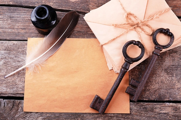Chaves antigas com tinta de papéis e caneta sobre fundo de madeira fecham
