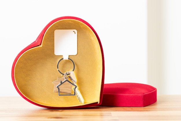 Foto chaves de casa e caixa de presente em forma de coração conceito de compra de casa como presente