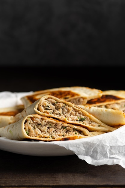 Cheburek caucásico tradicional con carne y verduras en un plato sobre fondo de madera con espacio para copiar