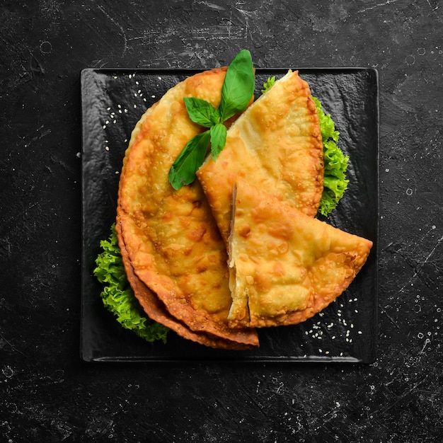 Cheburek de cozinha tártara oriental uzbeque com carne e queijo suluguni vista superior prato tradicional turco e mongol espaço para cópia gratuita