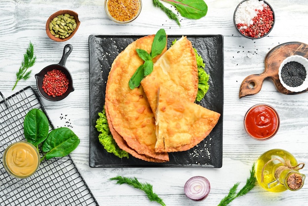 Foto cheburek de cozinha tártara oriental uzbeque com carne e queijo suluguni vista superior prato tradicional turco e mongol espaço para cópia gratuita