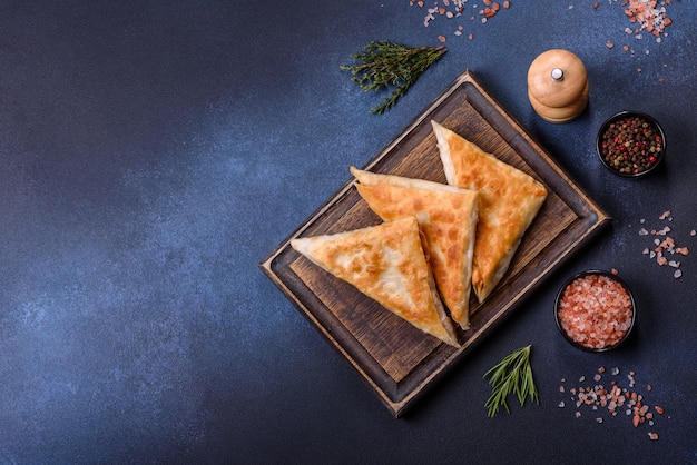 Chebureks fritos caseros con carne y hierbas en una tabla para cortar