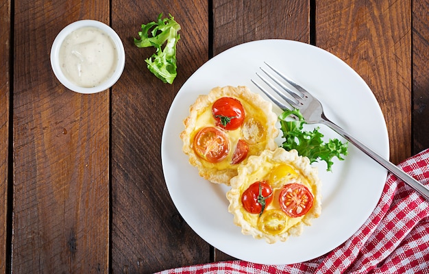 Cheddar, tomates tartaletas sobre madera