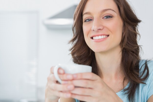 Cheerful morena segurando xícara de café