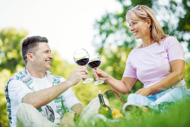 CheersLaughing pareja haciendo un picnic en el campo