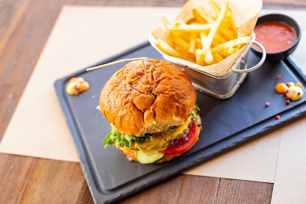 Cheese Burger American Cheese Burger mit frischem SalatJunk FoodHamburger mit Pommes auf den Brettern...