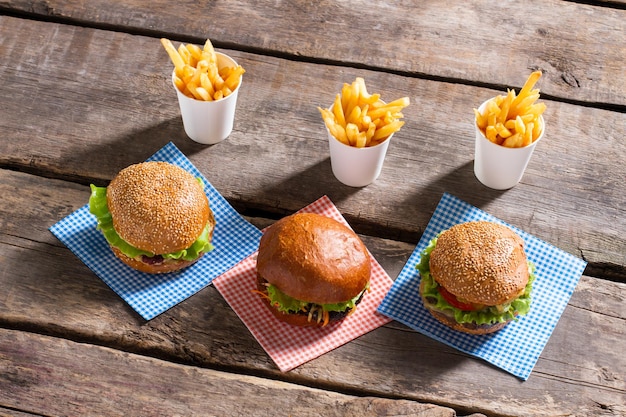 Cheeseburger auf Servietten und Pommes.