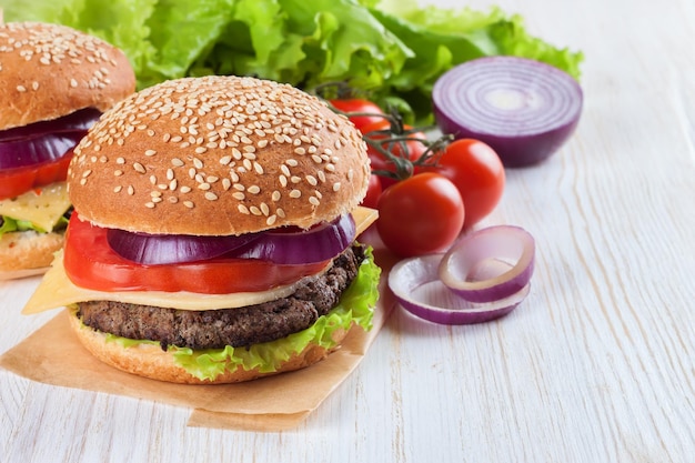 Cheeseburger caseiro na superfície de madeira branca