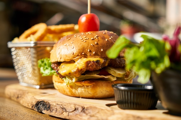 Cheeseburger com batatas fritas na mesa de madeira