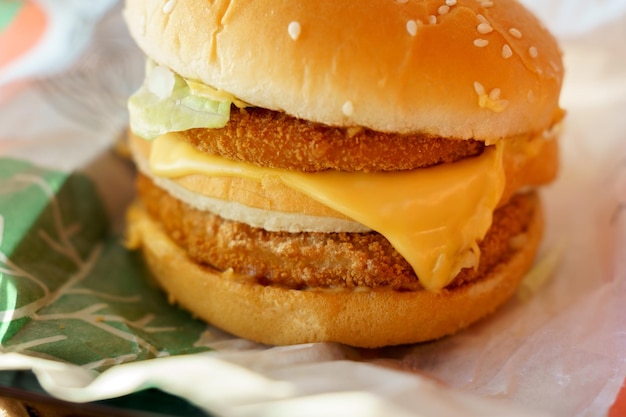 Cheeseburger com cutlet duplo em close-up em um restaurante de fast food