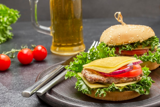 Cheeseburger mit grünem Messer und Gabel auf rundem Brett