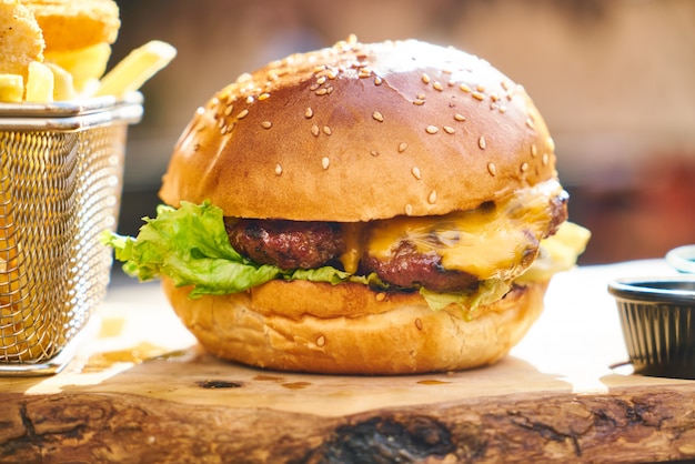 Cheeseburger mit Pommes-Frites auf dem Holztisch