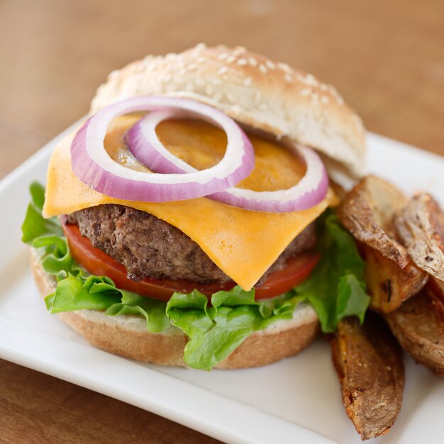 Cheeseburger mit Zwiebeln, Salat und Tomaten