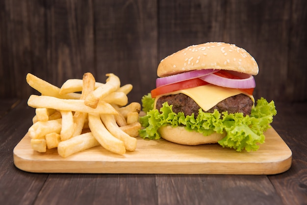 Cheeseburgers com batatas fritas no fundo de madeira