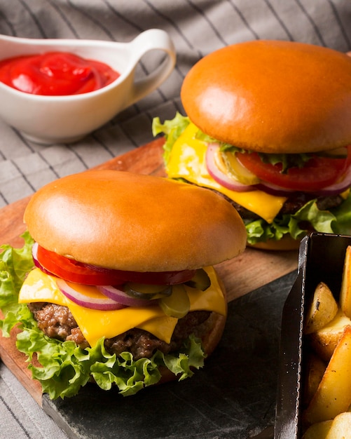 Foto cheeseburgers de ângulo alto na tábua de corte