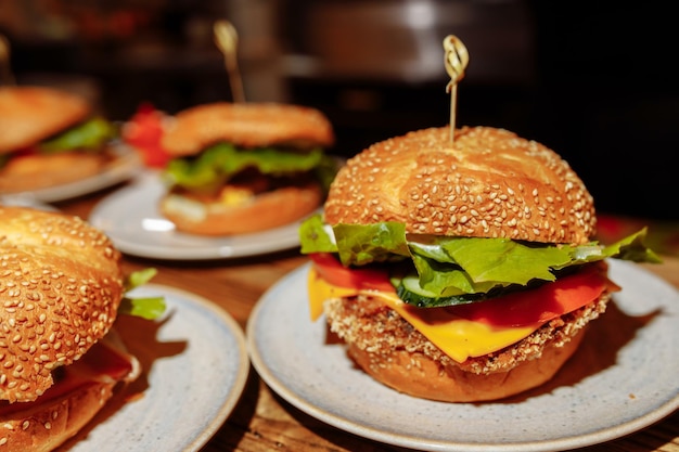 Cheeseburgers e batatas fritas em cima da mesa com cebola, tomate, alface e queijo