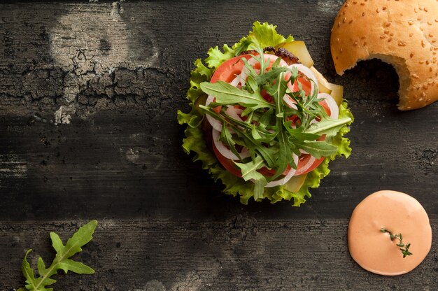 Cheeseburguer em uma velha superfície de madeira de cor escura Hambúrguer com molho e ketchup