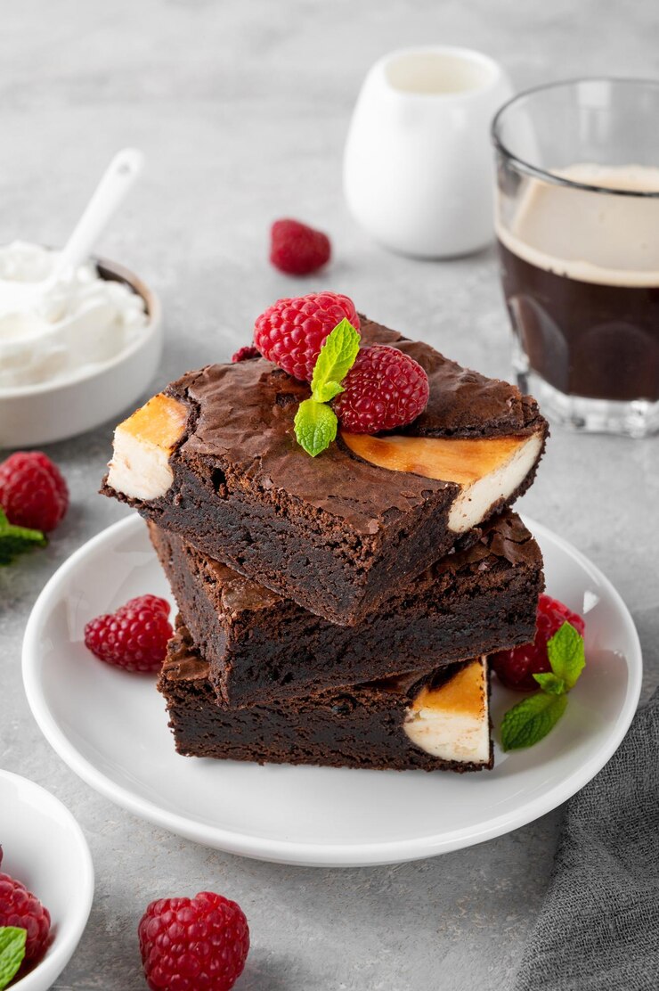 Cheesecake-Brownies mit Himbeeren auf einem grauen Beton-Hintergrund köstliches Dessert