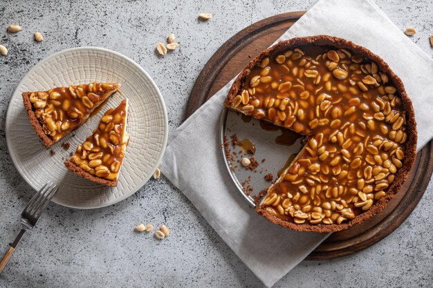 Cheesecake caseiro de caramelo e amendoim sobre um fundo claro Bolo delicioso de padaria matinal