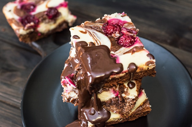 Cheesecake de chocolate em camadas com brownie e cereja escura. bolo de chocolate. pedaços de choco