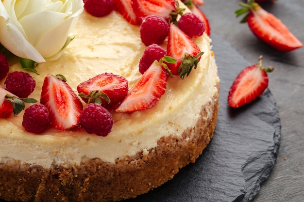 Cheesecake de coalhada decorado com frutas vermelhas e rosas